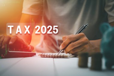 Eller 2025 yılının vergilerini hesaplamak için bir hesap makinesi kullanıyor ve kayıt yapıyor.