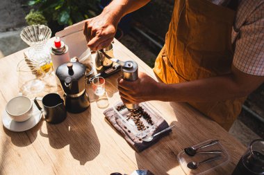Üst Manzara, Barista taze bir bira hazırlıyor. Elle paslanmaz çelik öğütücü kullanarak. Kırsal bir kafede lezzetli ve aromatik kahve deneyimi.