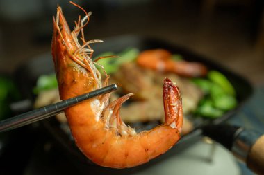 Paslanmaz çelik çubuklar kullanarak ızgara karides ya da MO KA, tavada ızgara yemek, Asya usulü yemek var..