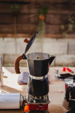 Kahve demliğinde kahve hazırlıyor, sıcak mutfağın fırınında dikkatlice demleniyor, zamansız ve aromalı kahve yapma ritüeli. Dikey fotoğraf