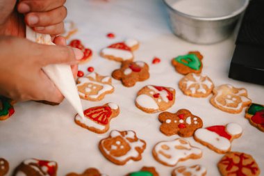 Neşeli eller iş yerinde tatlı Noel kurabiyeleri pişiriyor ve süslüyor, mevsimi şenlikli bir hazırlık ve herkese tatlı ikram ederek kutluyorlar.