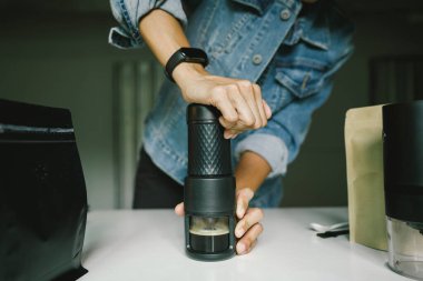 Ev yapımı espresso alabilmek için taşınabilir bir kahve makinesinin manuel basınçlı pompasına basan kahveyi hazırlıyorum..