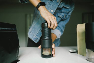 Ev yapımı espresso alabilmek için taşınabilir bir kahve makinesinin manuel basınçlı pompasına basan kahveyi hazırlıyorum..