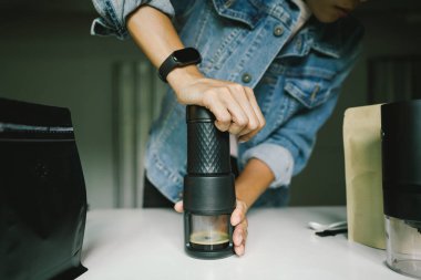 Ev yapımı espresso alabilmek için taşınabilir bir kahve makinesinin manuel basınçlı pompasına basan kahveyi hazırlıyorum..