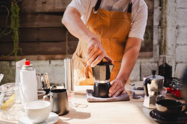 Kahveci klasik Moka demliği yapar. Portatif bir gaz sobasının üzerinde espresso yapar. Taze kahve kokusu yayar..