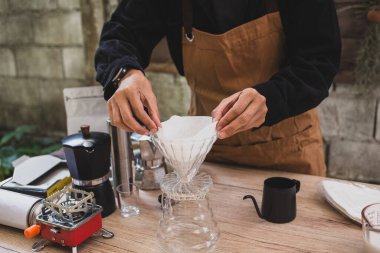 Kahveci, kağıt filtreye dökülen kahveyi hazırlar. Ev yapımı demleme işlemi. Özel kahve için ustalık hassasiyeti deneyimi..