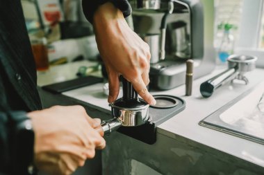 Kahveli içecek menüsüne kahve hazırlayan 58 mm Portafilter kullanan Hand 'i hazırlayın. Yakın plan.