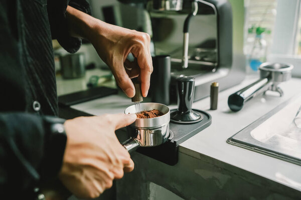 Close-up of coffee powder spreading in the brewing handle to prepare a coffee drink menu.