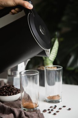 El 'in Kettle ile hazırlanması sıcak suyu bir fincan hazır kahveye dökmesi ev yapımı Espresso kahvesi, ev yapımı dikey fotoğraf.