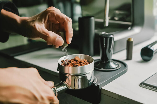 Close-up of coffee powder spreading in the brewing handle to prepare a coffee drink menu.