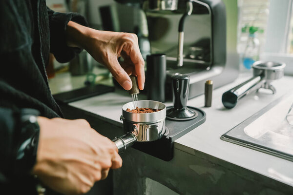 Close-up of coffee powder spreading in the brewing handle to prepare a coffee drink menu.