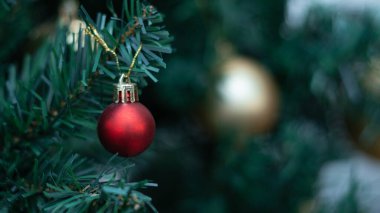 Kırmızı toplarla süslenmiş şenlikli Noel ağacı arka planı kutluyor..