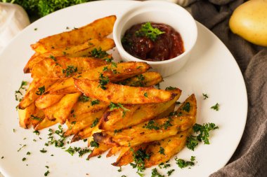 Top view baked potatoes, seasoned with paprika and garlic, topped with fresh parsley and rich tomato sauce an irresistible homemade dish served fresh from the oven.	