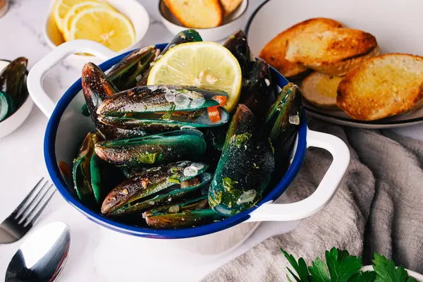 Taze pişmiş midye, doğranmış sarımsak, domates, limon ve otlarla servis edilir. Fransız ekmeğiyle süslenir, denizden tabağınıza kadar lezzetli deniz ürünleri sunulur.. 