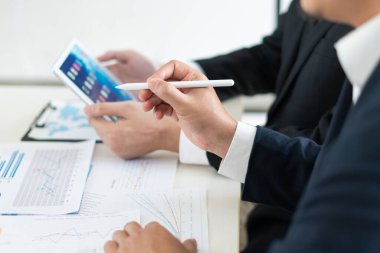 İş adamı, ofis masasında iş bilgilerini açıklarken ve tartışırken elinde bir kalem tutuyor ve profesyonel toplantı sırasında net görüşler sağlıyor..