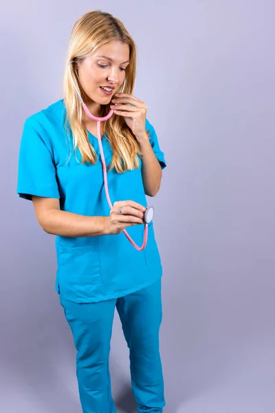 Junge Blonde Krankenschwester Mit Stethoskop Und Patientin Auf Grauem Hintergrund — Stockfoto
