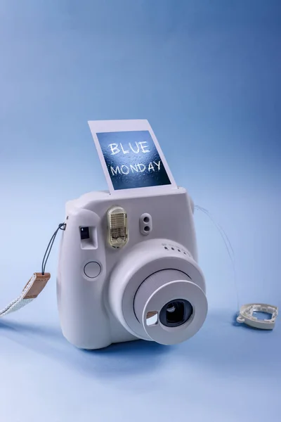 Blue Monday concept. Instant camera with a blue photo and message.