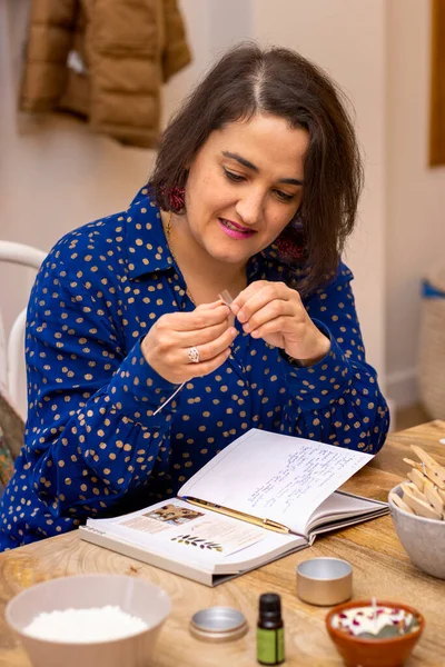 Young woman smiling in a soy wax candle workshop.