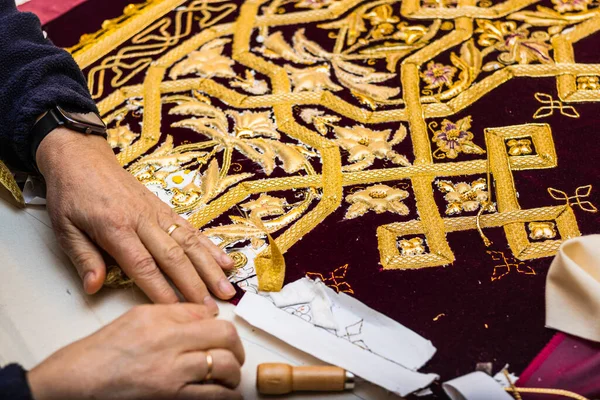 stock image Holy Week textile manufacturing. Close-up of an elderly woman's hands embroidering.