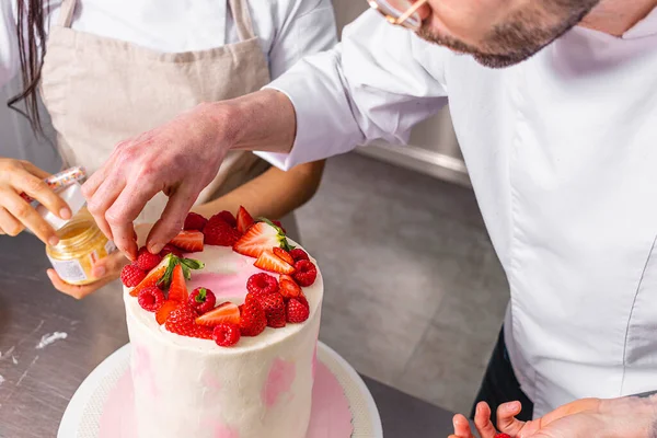 stock image Colombian Pastry Chef. Two chefs working on a strawberry and raspberry cake