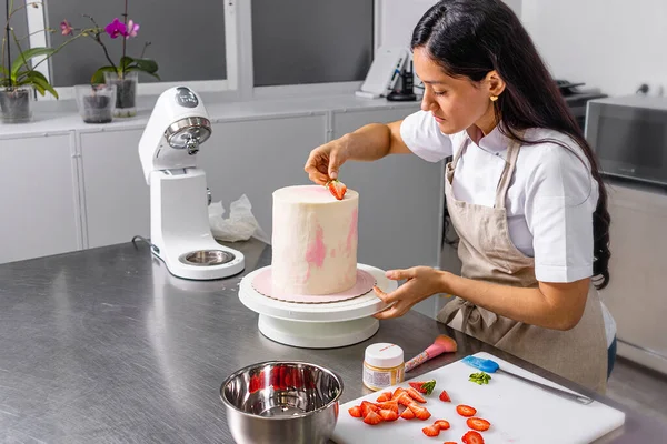 Colombian Pastry Chef. Begin the step of decorating the cake with fruit.