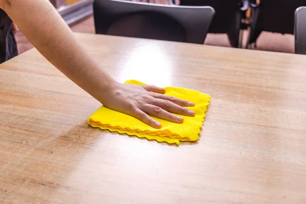 Waitress cleaning the bar table with a yellow cloth