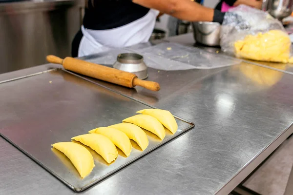 stock image Baker working with a rolling pin the dough for the pies.