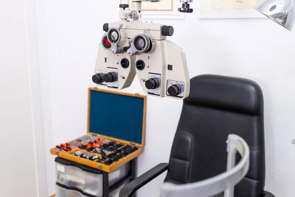 Optician and optometrist. Phoropter with a briefcase with lenses to measure eyesight in the background.