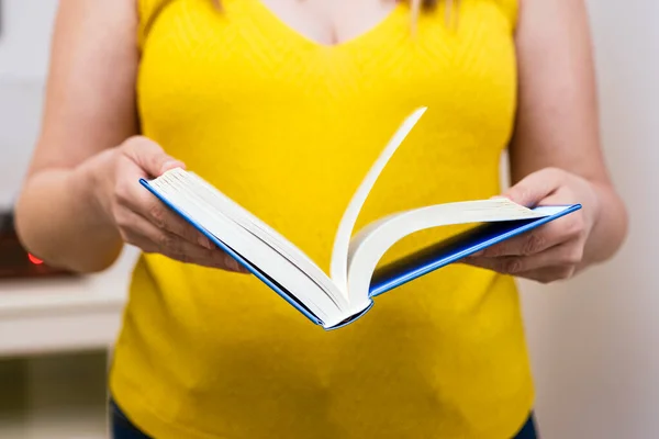 Close Das Mãos Uma Mulher Vestida Amarelo Abrindo Livro — Fotografia de Stock