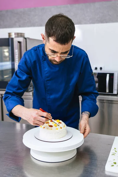 Pastry Chef. Male pastry chef working on his cake.