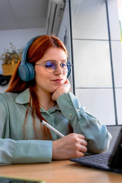 Stock image Redhead Girl. Telework Charm: Lovely Redhead Mastering Remote Work from a Cafe