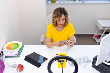 Diyetisyen diyet kliniği. Kadın doktor internette tıbbi danışmanlık yapmak için cep telefonunu kullanıyor..