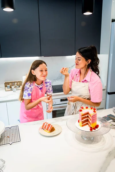 Happy mother and daughter baking sweet treats.