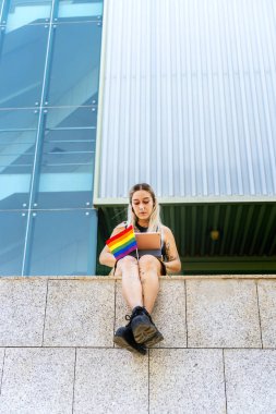 LGTBI üniversiteli kız. Bacaklarının arasında gurur bayrağı olan modern bir kız dövmesi..