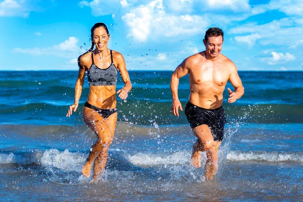 Run fit people running on beach with healthy toned legs body, Hamstring muscles
