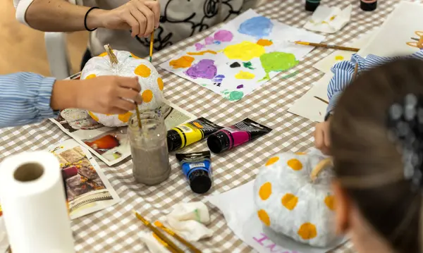 Children\'s painting class. Painting day with parents in class painting pumpkins.