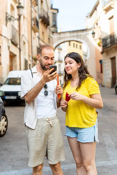 stock image Couple checking their cell phone to find their way while sightseeing