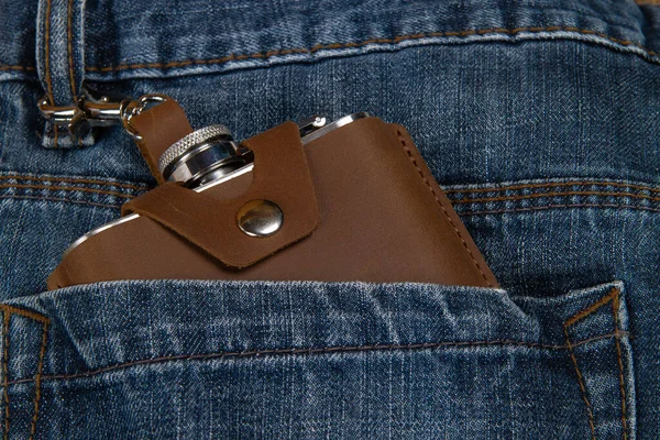 Hip flask in full grain leather case in denim blue jeans pocket