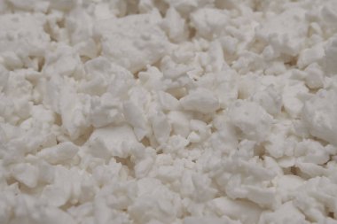 Protein-rich dairy product close-up. Cottage cheese texture background. Side view. Selective focus.