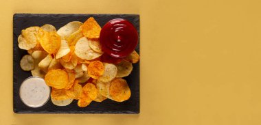 Zarif beyaz ve keskin kırmızı soslu ince ve çıtır patates cipsi.