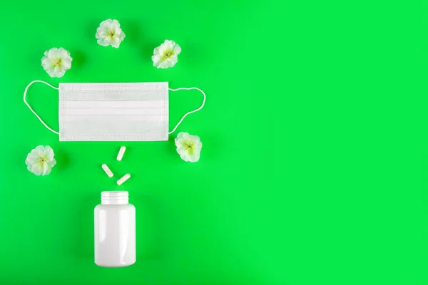 Cerrahi Maskeli Yeşil Arka Plan Kapsül Hapları Beyaz Çiçeklerin Arasına — Stok fotoğraf