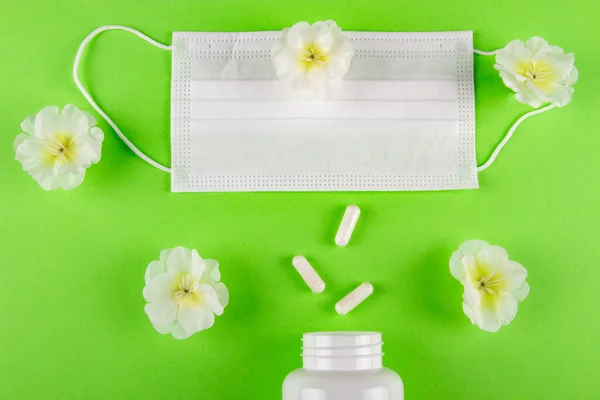 Yeşil Arka Plandaki Beyaz Çiçekler Tıbbi Maske Kapsül Hapları Için — Stok fotoğraf