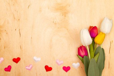 Lale çiçekleri ve ahşap arka planda fotokopi alanı olan küçük hertler. Aşk tılsımı çiçeklerle buluşur.
