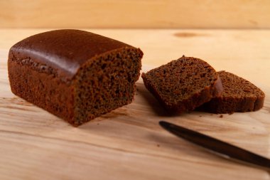 Açık bej rengi ahşap işlemeli somun ve koyu ekmek dilimleri. seçici odak