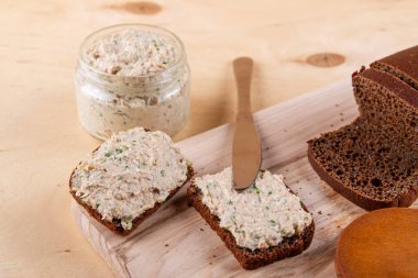 Çavdar ekmeği dilimleri sıcak ahşap arka planda sergileniyor.