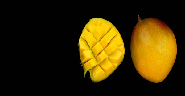マンゴーの果実全体と黒の背景に隔離されたマンゴーのスライス半分 トップビュー — ストック写真
