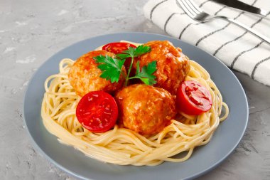Kaynamış spagetti ve domates soslu köfte, yakın plan.