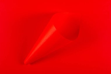 Kırmızı arka planda boş kırmızı kağıt koni var. Canlı renkler. Atıştırmalıklar için paket modellemesi.