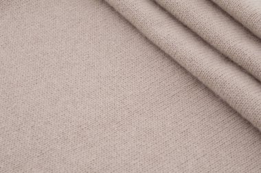 Katlanmış bej yün örgü kumaş dokusu arkaplanı