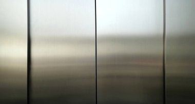 Stainless steel large sheet  With light hitting the surface  For background,Inside passenger elevator,Reflection of light on a shiny metal surface,stainless steel background.